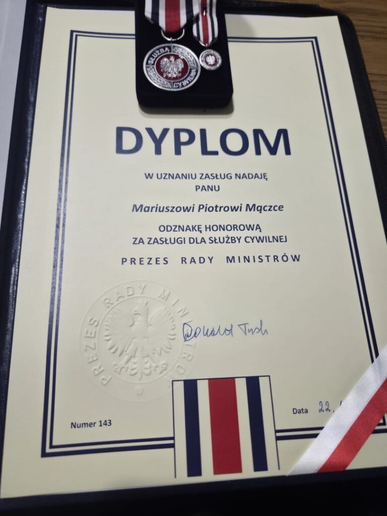 Dyplom nadania Odznaki Honorowej za Zasługi dla Służby Cywilnej Mariuszowi Piotrowi Mączce – podpisany przez Prezesa Rady Ministrów Donalda Tuska, luty 2026.